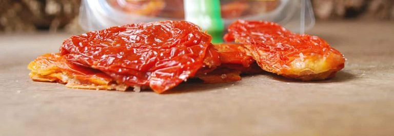 Due pomodori secchi su tavolo di legno