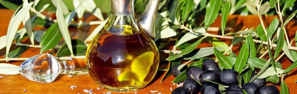 Olio sardo in bottiglia di vetro con olive nere