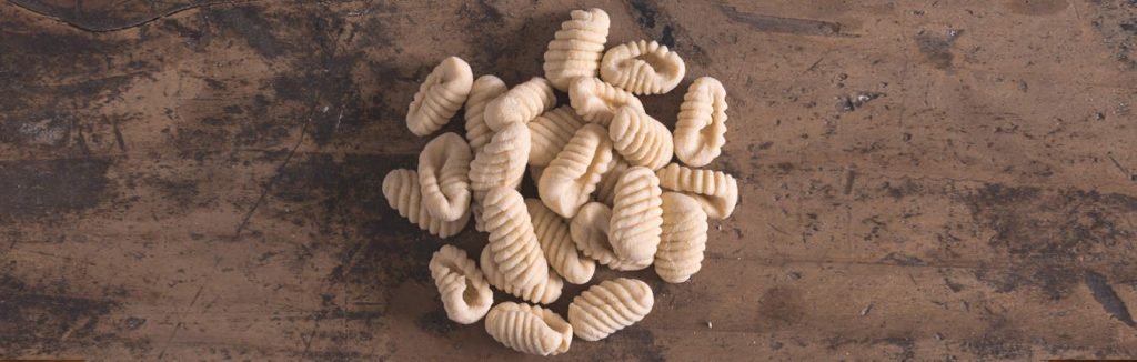 Malloreddus fatti in casa freschi su tavolo marrone