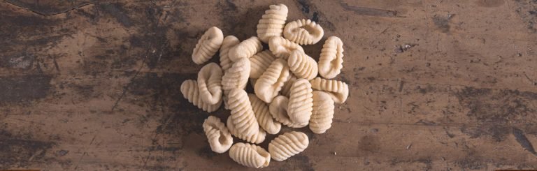 Malloreddus fatti in casa freschi su tavolo marrone